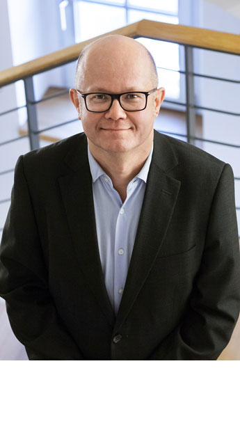 Torsten Tannenberg, dunkle Brille, Glatze, helles Hemd, dunkles Jackett