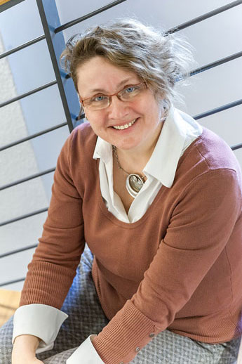 Ulrike Kirchberg sandfarbener Pullover, helle, offene Bluse, kurze blonde Haare, Brille