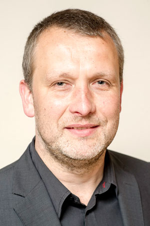 Jörg-Michael Schlegel, kurze dunkle Haare, Bart, schwarzes Hemd und Jackett