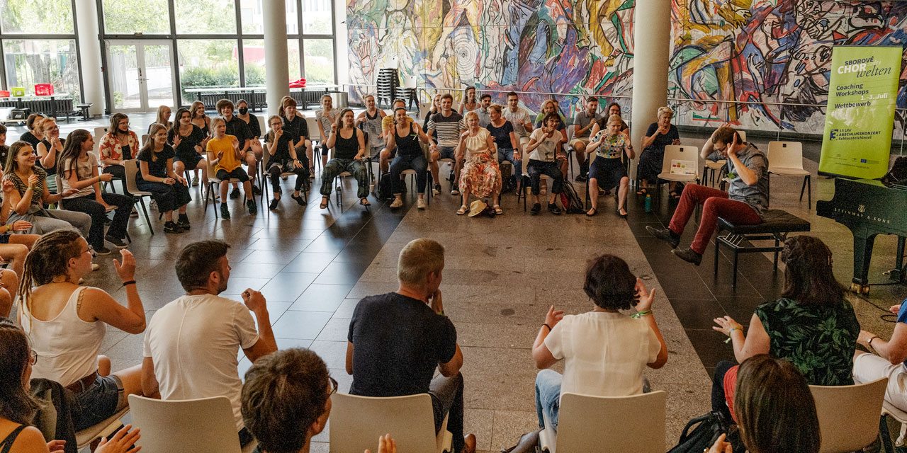 Ein Coaching im bunten Foyer der Chemnitzer Stadthalle, die Menschen sitzen im Stuhlkreis