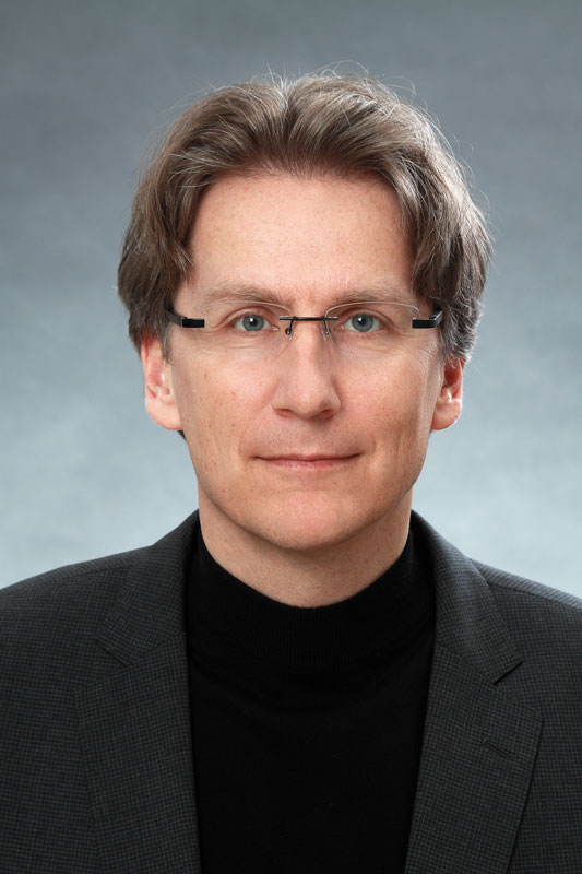 Professor Dirk Mürbe, dichte blonde Haare, Brille
