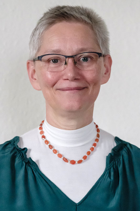 Kristin Haas, rote Kette, Brille, graue kurze Haare