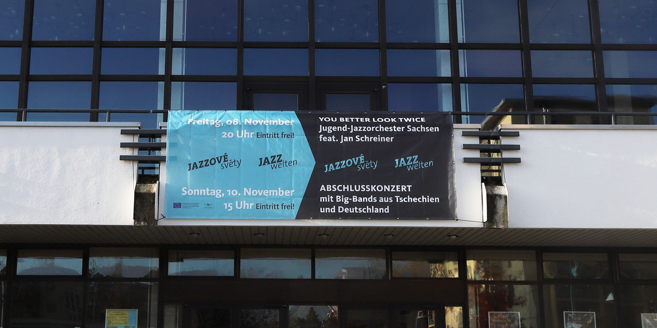 Ein Banner mit Werbung für die Jazzwelten 2019 hängt an einem Gebäude.