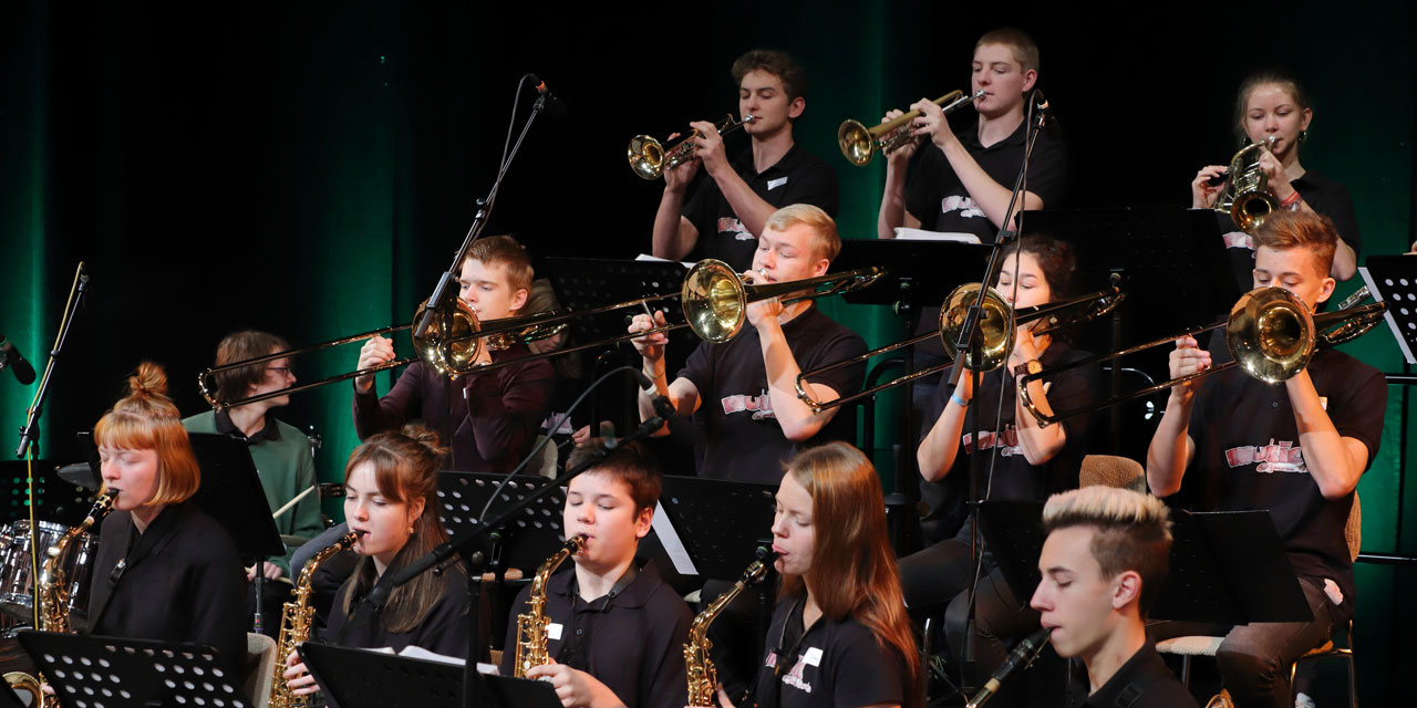 Jugendliche spielen in einem Jazzorchester in schwarzer Kleidung