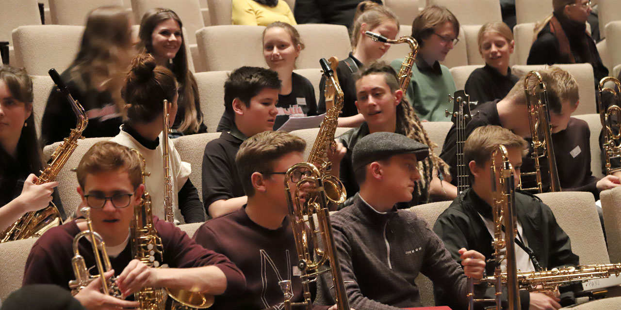 Jugendliche unterhalten sich und haben ihre Instrumente in der Hand