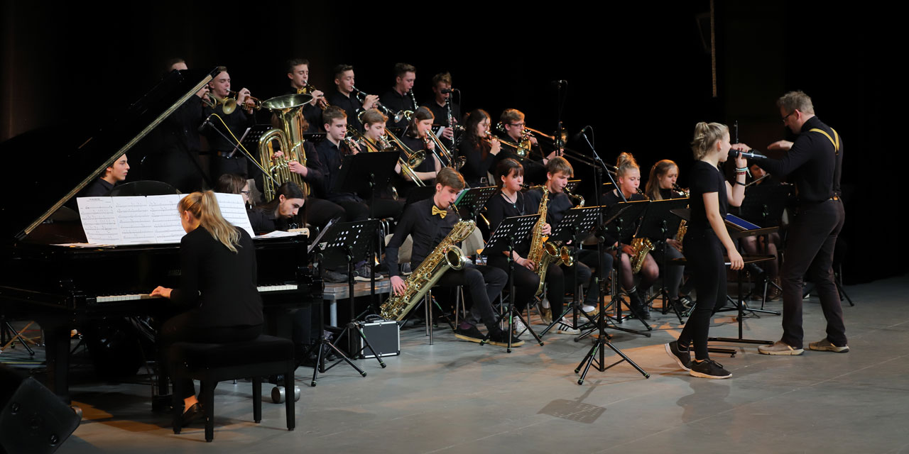 Ein Jazzorchester spielt und alle sind einheitlich in schwarz gekleidet