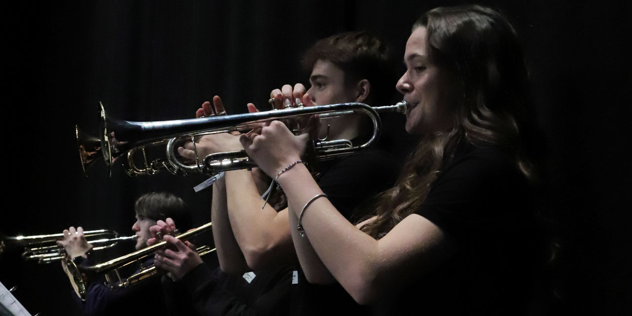 Eine seitliche Aufnahme von vier Jugendlichen, welche Trompete spielen.