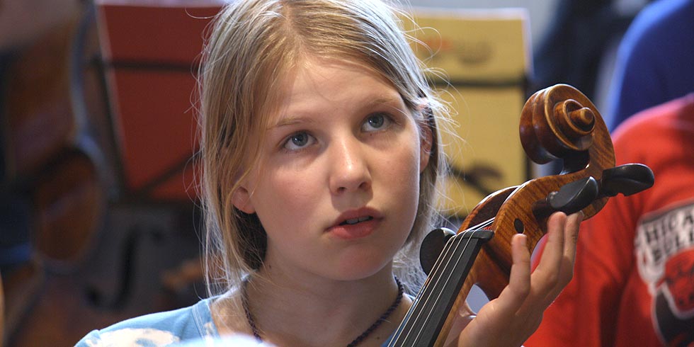Ein junges Mädchen konzentriert beim Cello üben