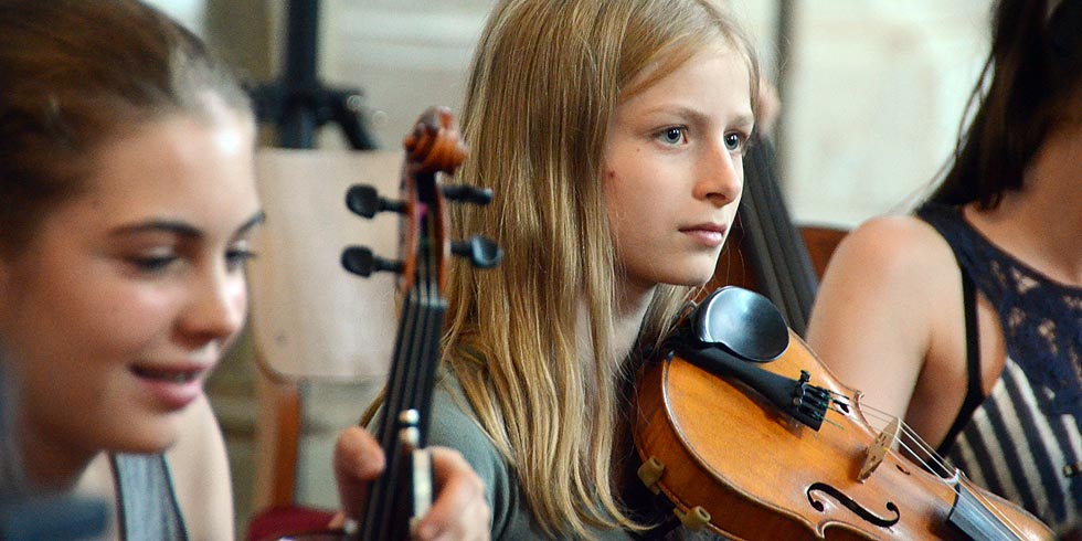 Nahaufnahme von drei jungen Mädchen bei der Orchesterprobe.