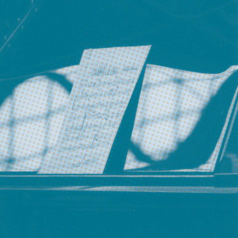 Ein Notenblatt liegt auf einem Flügelnotenständer, bläulich mit Schattenreflexen.