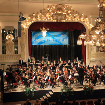 Ein Orchester sitzt auf einer Bühne